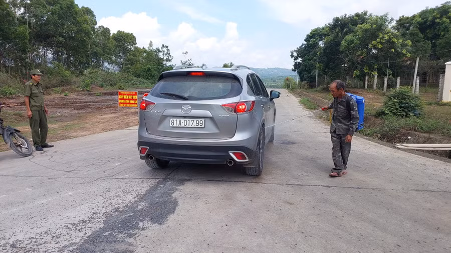 Lực lượng chức năng xã Đak Jơ Ta tiêu độc, khử trùng các phương tiện ra vào vùng dịch bệnh LMLM. Ảnh: Nguyễn Diệp