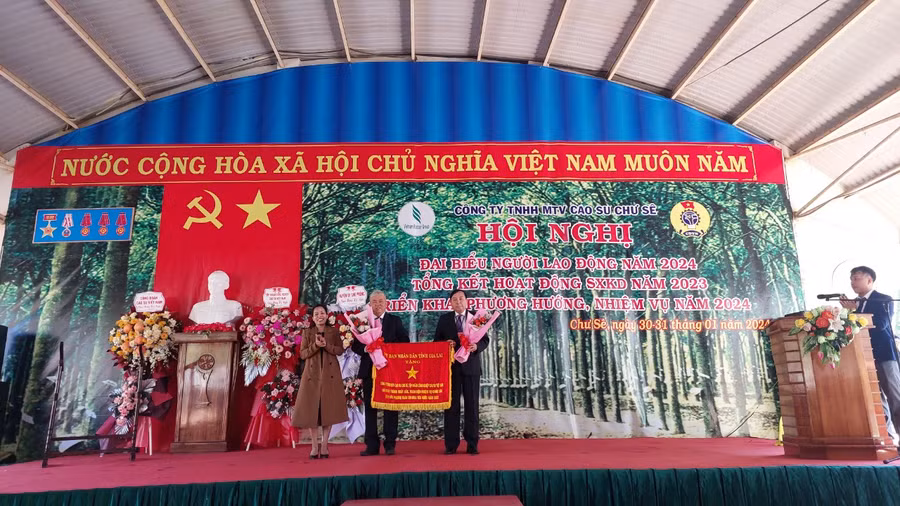 Thừa ủy quyền của Chủ tịch UBND tỉnh, Chủ tịch UBND huyện Chư Sê tặng cờ Thi đua của UBND tỉnh cho Công ty TNHH một thành viên Cao su Chư Sê. Ảnh: Nguyễn Diệp