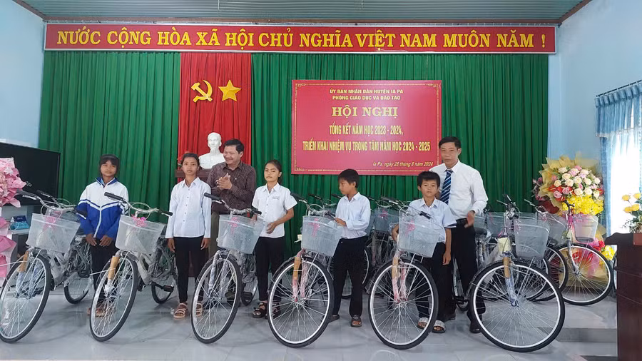 Phó Chủ tịch Thường trực HĐND tỉnh (áo xám bìa trái) cùng Bí thư Huyện ủy Ia Pa Nguyễn Minh Trưởng tặng xe đạp cho các em học sinh. Ảnh: Nguyễn Diệp