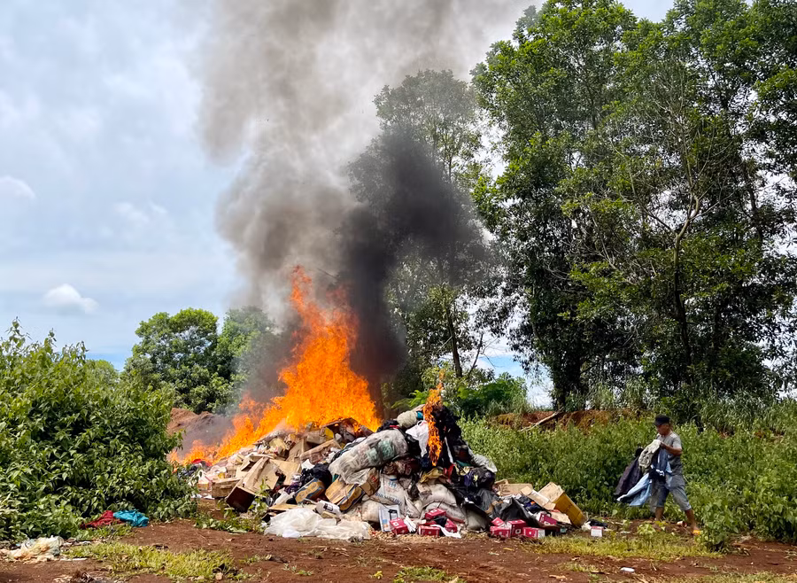 Tiêu huỷ hàng hóa vi phạm bằng cách dùng xăng dầu đốt. Ảnh: Vũ Thảo
