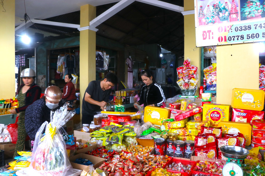 Chị Thân Thị Thu Thủy (bìa phải)-tiêu thương chợ Chí Công (thôn Hiệp An, xã Tân An, huyện Đak Pơ) tất bật tính tiền hàng cho khách. Ảnh: Ngọc Minh Chị Thân Thị Thu Thủy (bìa phải)-tiêu thương chợ Chí Công (thôn Hiệp An, xã Tân An, huyện Đak Pơ) tất bật tính tiền hàng cho khách. Ảnh: Ngọc Minh