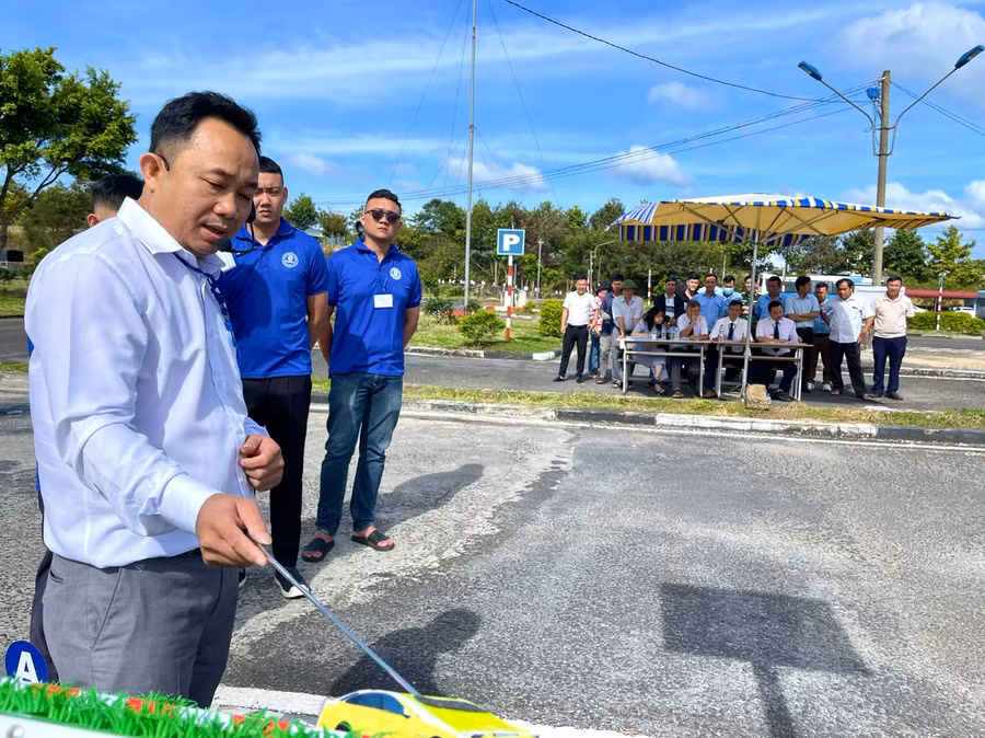 Giáo viên Trung tâm Đào tạo và Sát hạch lái xe tham gia phần thi lý thuyết và thực hành ghép xe dọc vào nơi đỗ. Ảnh: Minh Phương
