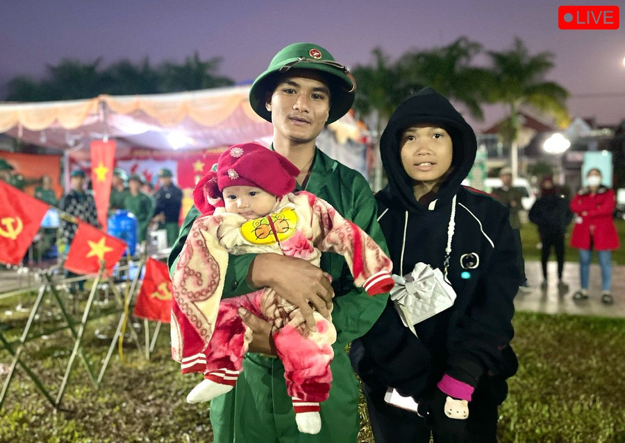 Được vợ và gia đình ủng hộ, tân binh Đinh Văn Hiệp (SN 2005, làng Mơ Hra-Đáp, xã Kông Lơng Khơng) tạm chi tay vợ và đứa con mới tròn 3 tháng tuổi để lên đường nhập ngũ. Ảnh: Minh Phương