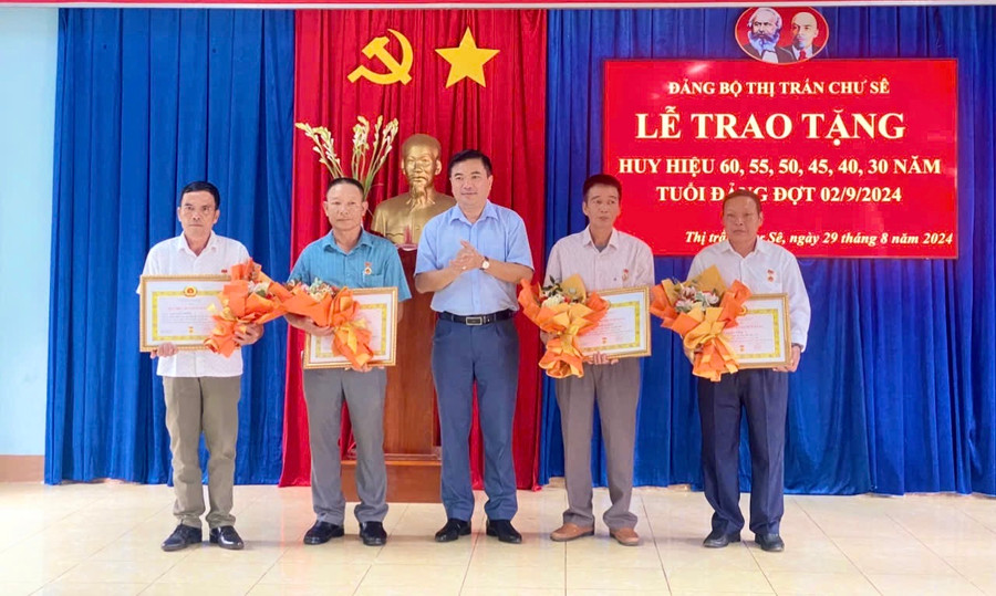 Bí thư Huyện ủy Lý Anh Sang trao Huy hiệu Đảng cho các đảng viên. Ảnh: Trúc Phùng