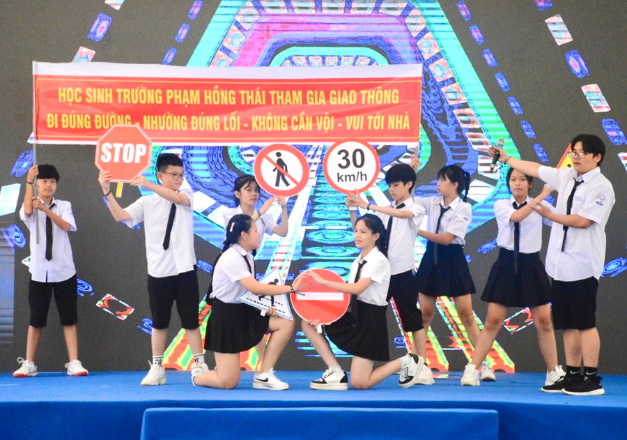 Tiết mục biểu diễn của các em học sinh trường THCS Phạm Hồng Thái cùng với thông điệp tuyên truyền về an toàn giao thông. Ảnh: Minh Phương