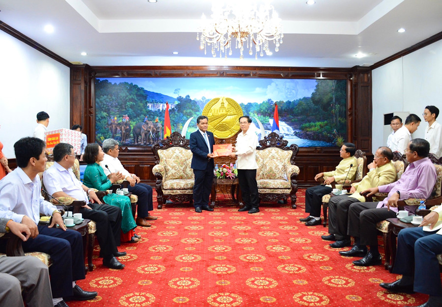 Thay mặt đoàn công tác Bí thư Tỉnh ủy Hồ Văn Niên (bên trái) trao tặng số tiền của tỉnh 20.000 USD (tương đương 480 triệu đồng) cho tỉnh Salavan cùng những lời chúc mừng năm mới tốt đẹp. Ảnh: Minh Nguyễn