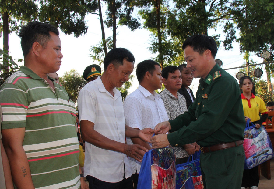 Đại tá Nguyễn Văn Nghị-Phó Chính ủy BĐBP trao tặng quà cho hộ nghèo ở xã Ia O. Ảnh: T.D