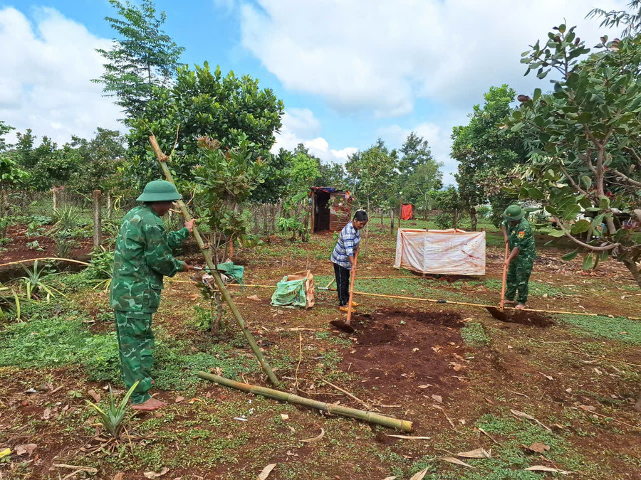 Cán bộ, chiến sĩ Đồn Biên phòng Ia Chía giúp gia đình bà Puih Denh chuẩn bị làm vườn rau xanh. Ảnh: T.D