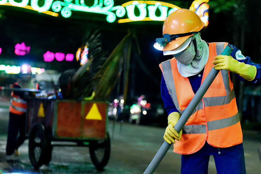 Mỗi người đảm nhận 1 công việc, trong đó, người cầm chổi có nhiệm vụ quét rác, người đi phía sau hốt rác kiêm đẩy xe.