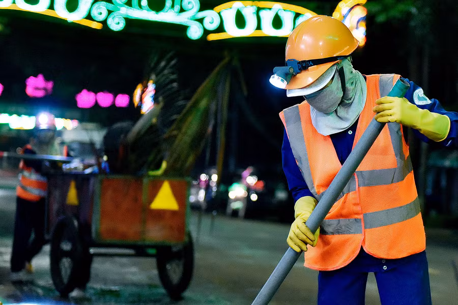 Mỗi người đảm nhận 1 công việc, trong đó, người cầm chổi có nhiệm vụ quét rác, người đi phía sau hốt rác kiêm đẩy xe.