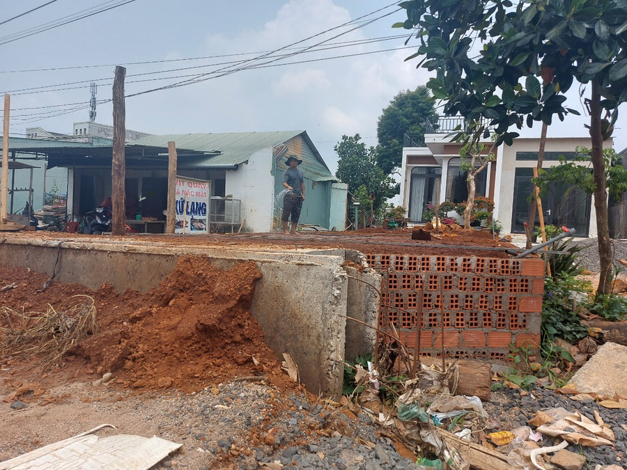 Gia đình anh Lê Văn Trí mua đất đổ nền nâng sân lên cao cho bằng nền đường quốc lộ 19 để tránh ngập. Ảnh: Nguyễn Tú