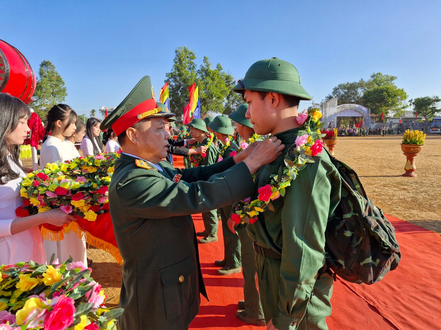 Đại tá Lê Kim Giàu tặng hoa và chỉnh quân phục cho thanh niên trước lúc lên đường về đơn vị thực hiện nghĩa vụ bảo vệ Tổ quốc. Ảnh: Vĩnh Hoàng