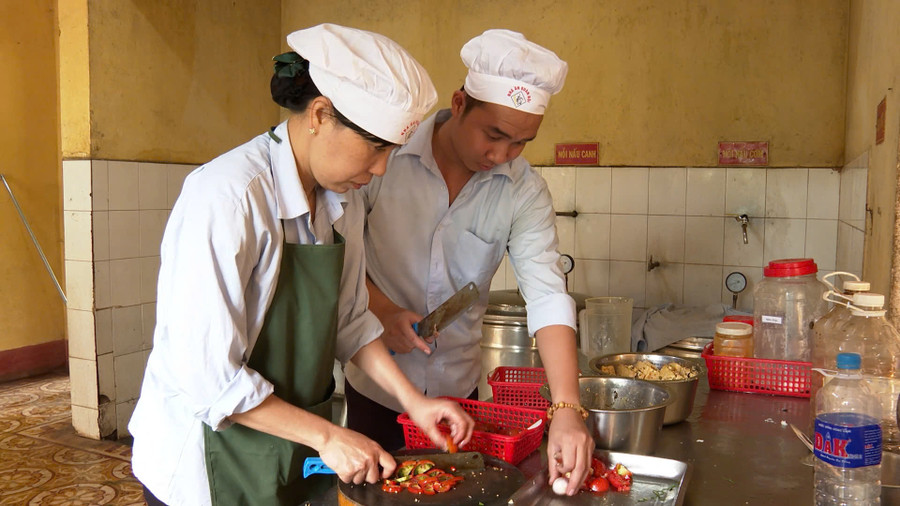 Chị Nga hướng dẫn nhân viên mới cách chế biến thức ăn. Ảnh: Vĩnh Hoàng Chị Nga hướng dẫn nhân viên mới cách chế biến thức ăn. Ảnh: Vĩnh Hoàng