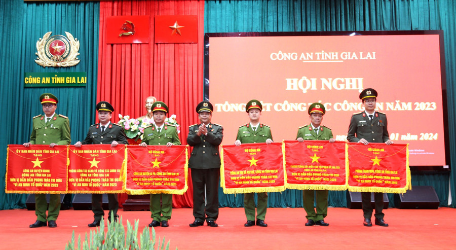 GI Giám đốc Công an tỉnh trao Cờ của Bộ công an và UBND tỉnh cho các tập thể. Ảnh: Vĩnh Hoàng