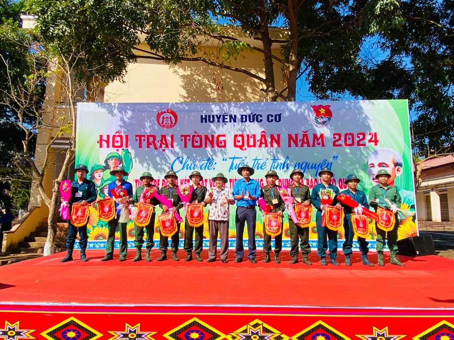 Lãnh đạo huyện Đức Cơ tặng cờ cho các đơn vị tham gia hội trại tòng quân. Ảnh: Vĩnh Hoàng Lãnh đạo huyện Đức Cơ tặng cờ cho các đơn vị tham gia hội trại tòng quân. Ảnh: Vĩnh Hoàng