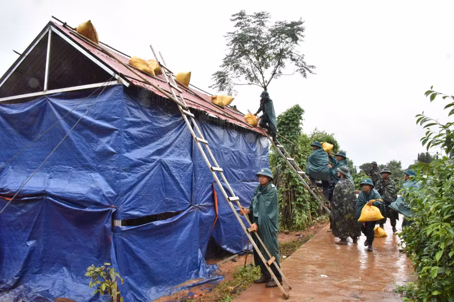 Lực lượng chức năng giúp người dân chằng chống nhà cửa. Ảnh: Đức Thụy