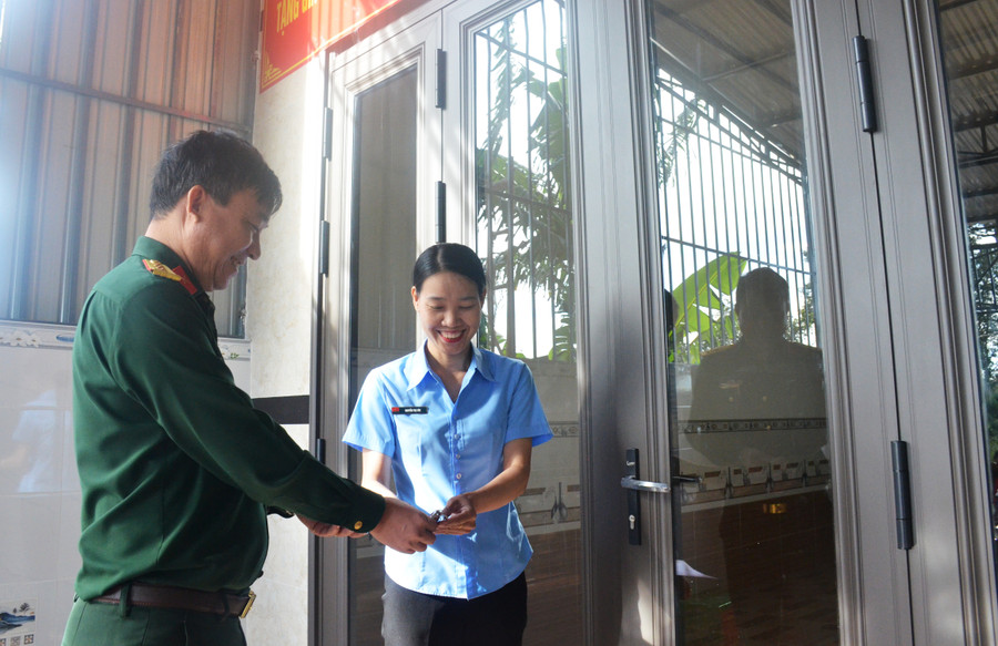 Lãnh đạo đơn vị trao chìa khóa sử dụng ngôi nhà cho gia đình chị Nguyễn Thị Cúc. Ảnh: Vĩnh Hoàng