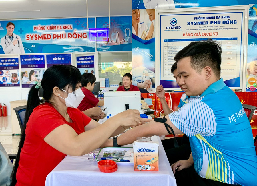Cán bộ y tế Bệnh viện Quân y 211 xét nghiệm sàng lọc cho người tham gia hiến máu tình nguyện tại Chương trình hiến máu tình nguyện Giọt hồng hệ thống y tế GEM. Ảnh: Như Nguyện