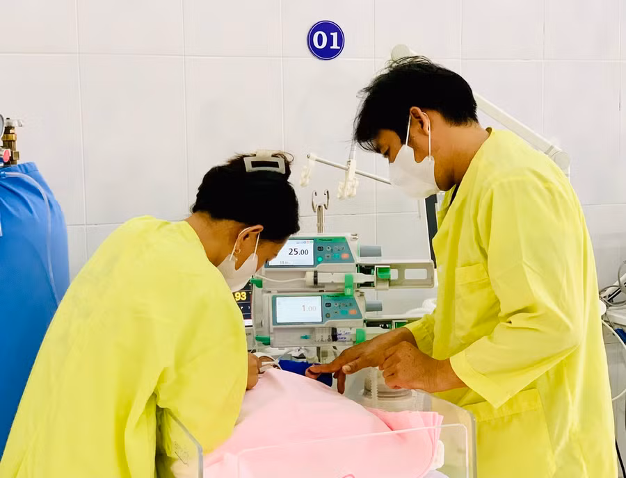 Vợ chồng chị N.T.D.L. đang chăm sóc bé. Ảnh: Như Nguyện