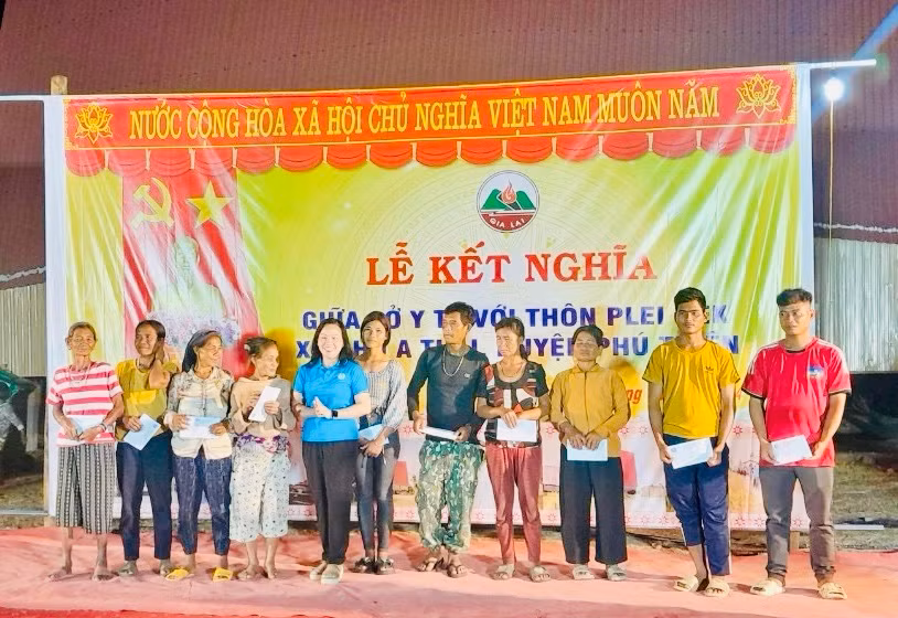 Bà Nguyễn Thị Ánh Xuân (áo xanh dương)-Chủ tịch Công đoàn ngành Y tế tỉnh trao tặng 10 suất quà (mỗi suất 300.000 đồng tiền mặt) đến các hộ nghèo, khó khăn thôn Plei Hek. Ảnh: Như Nguyện