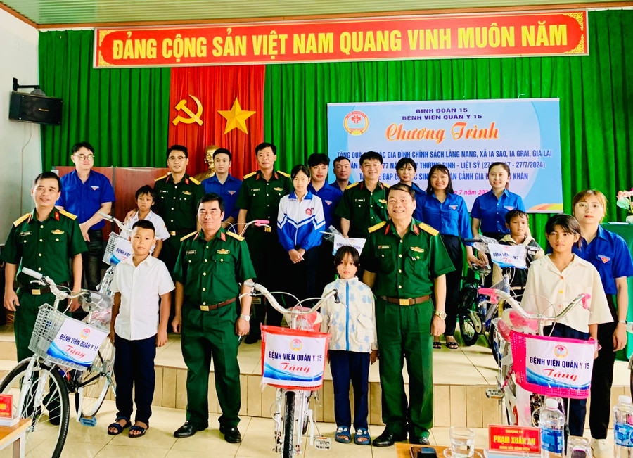 Đại diện lãnh đạo Binh đoàn 15, Ban Giám đốc Bệnh viện Quân y 15 trao 10 xe đạp đến các em học sinh nghèo, khó khăn tại làng Nang, xã Ia Sao, huyện Ia Grai. Ảnh: Như Nguyện