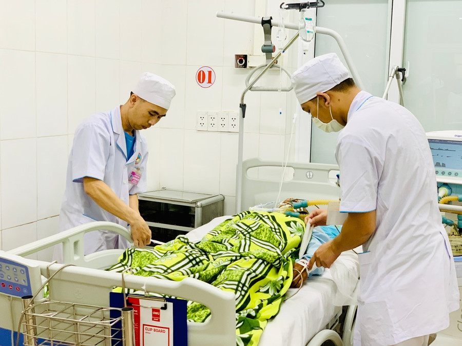Đại úy Nguyễn Như Bình (bên trái)- Điều dưỡng trưởng Khoa Nội 12 (Khoa Hồi sức tích cực- Bệnh viện Quân y 211) chăm sóc cho một bệnh nhân nặng. Ảnh: Như Nguyện