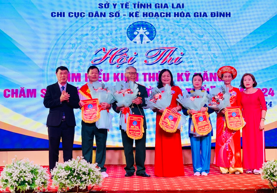 Ban tổ chức trao cờ và hoa cho đại diện 5 đội thi đến từ Câu lạc bộ chăm sóc sức khỏe người cao tuổi thuộc các huyện Ia Grai, Chư Prông, Chư Sê, Đak Đoa và TP. Pleiku. Ảnh: Như Nguyện Ban tổ chức trao cờ và hoa cho đại diện 5 đội thi đến từ Câu lạc bộ chăm sóc sức khỏe người cao tuổi thuộc các huyện Ia Grai, Chư Prông, Chư Sê, Đak Đoa và TP. Pleiku. Ảnh: Như Nguyện