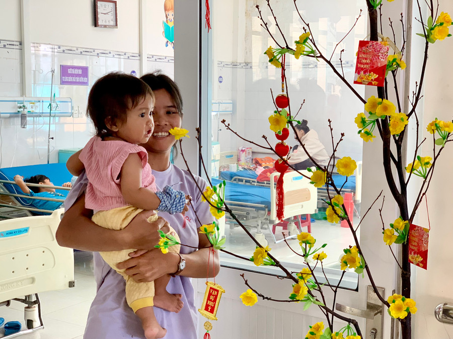 Một bệnh nhi thích thú cùng mẹ ngắm mai vàng. Ảnh: Như Nguyện Một bệnh nhi thích thú cùng mẹ ngắm mai vàng. Ảnh: Như Nguyện