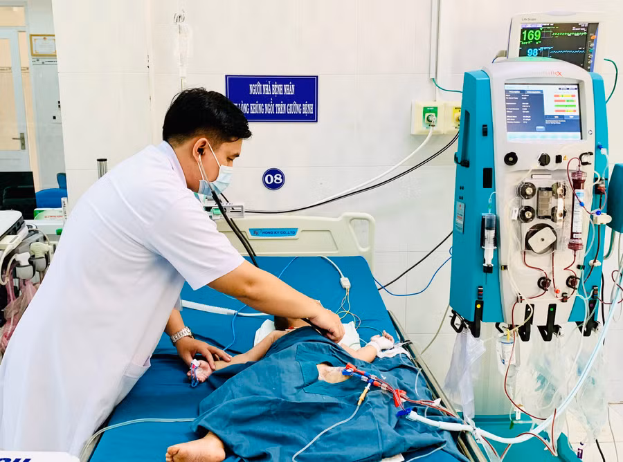 Bác sỹ Bùi Quốc Long thăm khám cho bệnh nhi S.D. Ảnh: Như Nguyện