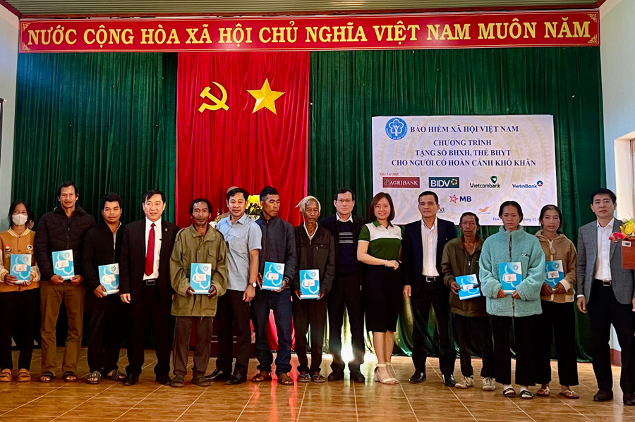 Đại diện các đơn vị, nhà tài trợ trao thẻ BHYT cho người dân. Ảnh: Như Nguyện