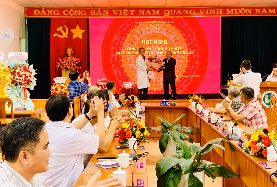 Ông Nguyễn Đình Tiến-Giám đốc Sở Nội vụ Gia Lai tặng hoa chúc mừng tiến sĩ Nguyễn Đăng Bảo. Ảnh: Như Nguyện