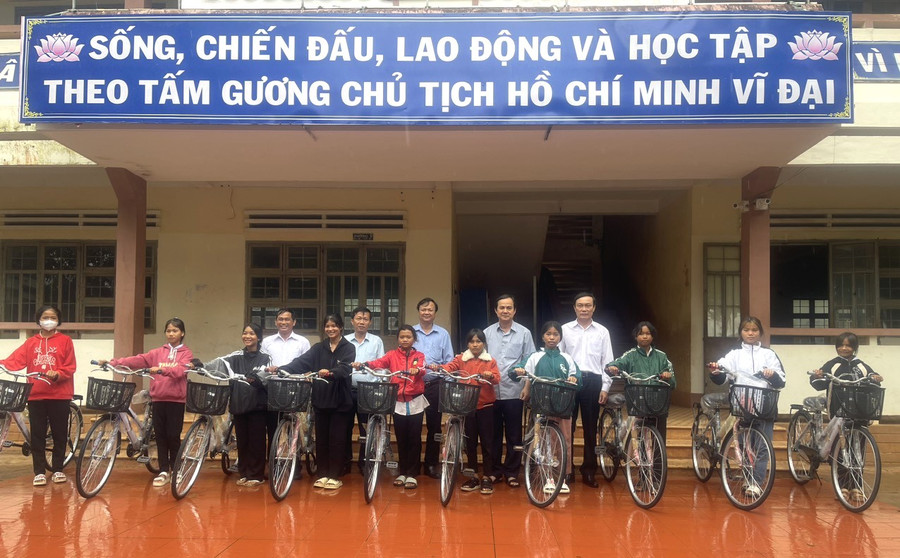 Trưởng ban Nội chính Tỉnh ủy Võ Thanh Hùng (hàng sau, thứ 2 từ phải sang) tặng 10 xe đạp cho 10 em học sinh Trường THCS Trần Phú. Ảnh: Hà Chi