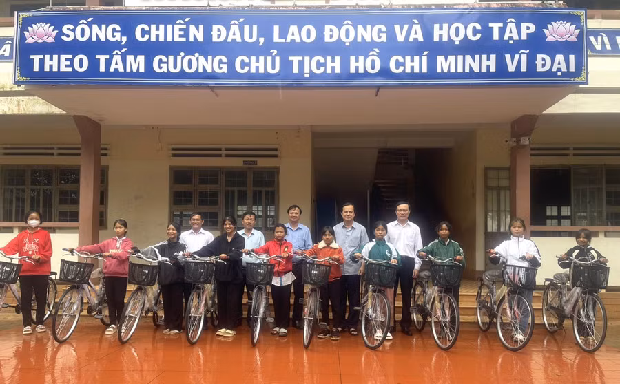 Trưởng ban Nội chính Tỉnh ủy Võ Thanh Hùng (hàng sau, thứ 2 từ phải sang) tặng 10 xe đạp cho 10 em học sinh Trường THCS Trần Phú. Ảnh: Hà Chi