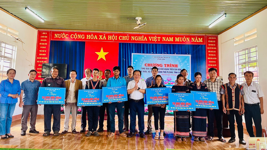 Lãnh đạo Sở Xây dựng trao quà hỗ trợ cho hộ nghèo, hộ khó khăn của làng. Ảnh: Nhật Hào