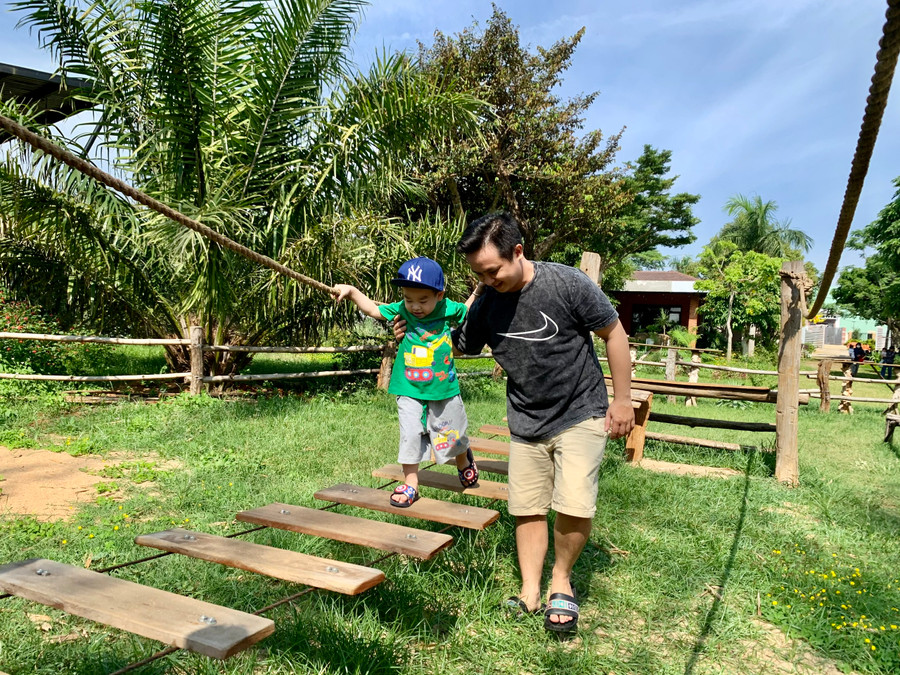 Anh Hàn Đạo Quân tranh thủ đưa con đi trải nghiệm các trò chơi vận động tại khu vui chơi ở quê nhà Gia Lai. Ảnh: Hồng Thương