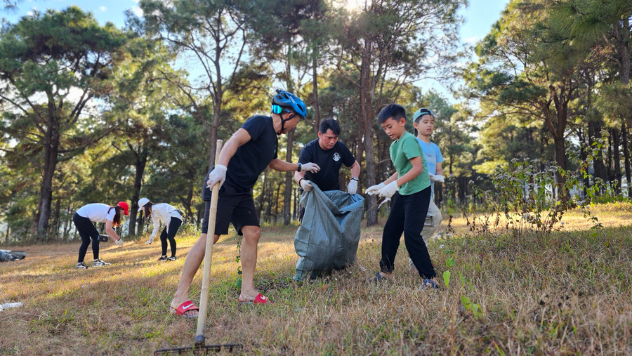 Các thành viên chia làm từng nhóm nhỏ để thu gom rác thải tại khu vực đồi thông. Ảnh: Nhật Hào