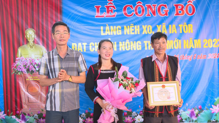 Ông Từ Ngọc Thông-Phó Chủ tịch Thường trực UBND huyện trao bằng công nhận làng Nẽh Xo đạt chuẩn nông thôn mới. Ảnh: Nhật Hào