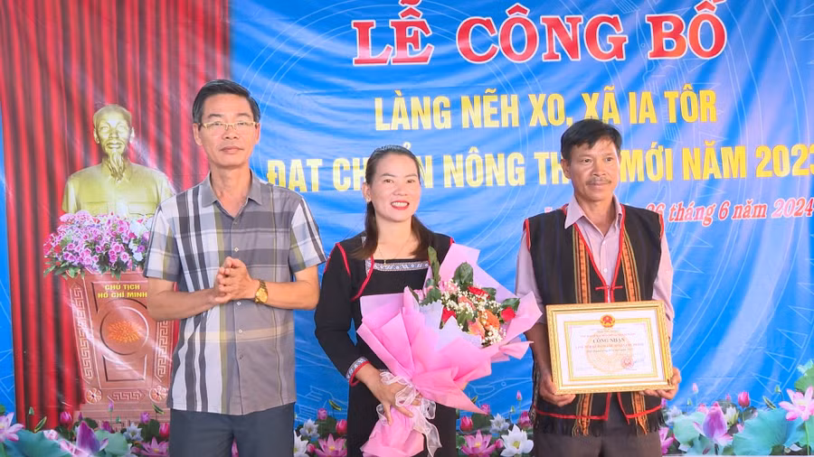 Ông Từ Ngọc Thông-Phó Chủ tịch Thường trực UBND huyện trao bằng công nhận làng Nẽh Xo đạt chuẩn nông thôn mới. Ảnh: Nhật Hào