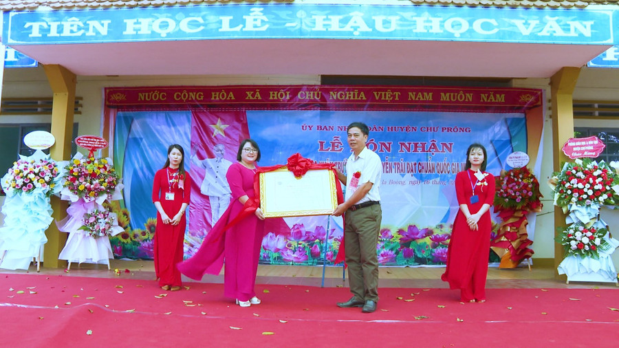 Phó Chủ tịch UBND huyện Ksor Việt trao bằng công nhận đạt chuẩn quốc gia mức độ 1 cho nhà trường. Ảnh: Hồng Thương Phó Chủ tịch UBND huyện Ksor Việt trao bằng công nhận đạt chuẩn quốc gia mức độ 1 cho nhà trường. Ảnh: Hồng Thương