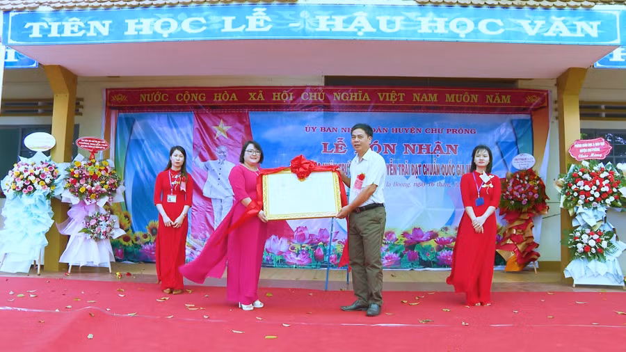 Phó Chủ tịch UBND huyện Ksor Việt trao bằng công nhận đạt chuẩn quốc gia mức độ 1 cho nhà trường. Ảnh: Hồng Thương