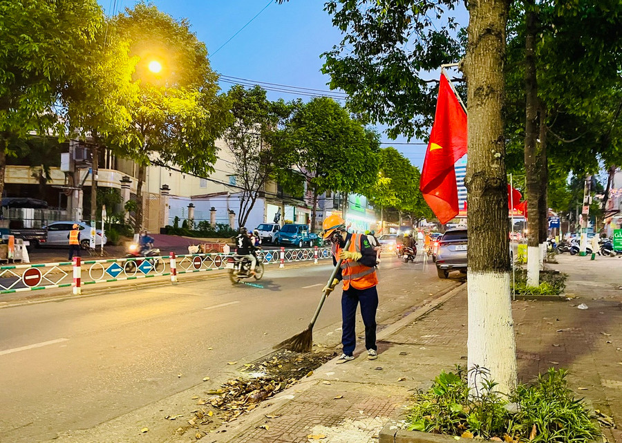 Những tiếng chổi của các chị lao công nhanh hơn, gấp gáp hơn trong ngày 30 tết. Ảnh: Nhật Hào