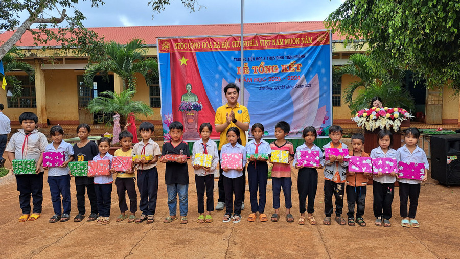 Em Văn Gia Hy (áo vàng) đã trích tiền khen thưởng từ các giải thi quốc gia đạt được trong năm học 2023-2024 để đóng góp mua quà cho các em học sinh có hoàn cảnh khó khăn tại trường. Ảnh: Nhật Hào