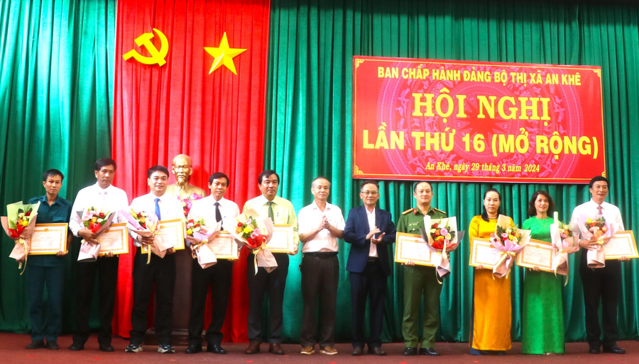 Bí thư Thị ủy An Khê Nguyễn Xuân Phước (thứ 5 bên phải) và Phó Bí thư Thường trực Thị ủy, Chủ tịch HĐND thị xã An Khê Nguyễn Hùng Vỹ (thứ 6 bên phải) trao giấy khen cho các tập thể. Ảnh: Ngọc Minh
