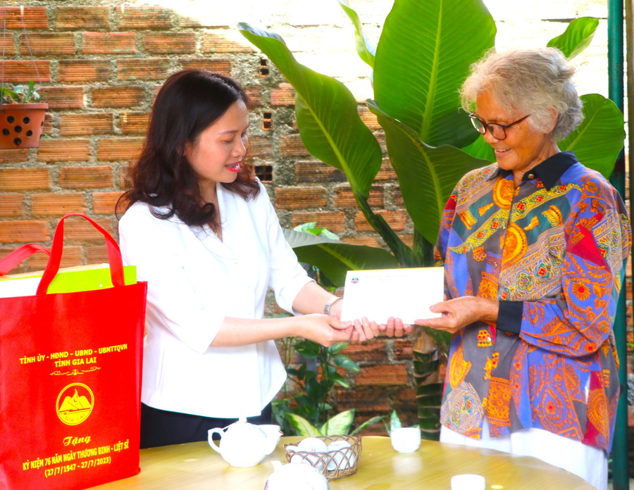 Thay mặt Tỉnh ủy, HĐND, UBND, Ủy ban MTTQ Việt Nam tỉnh, Tỉnh ủy viên, Phó Trưởng Đoàn Đại biểu Quốc hội Siu Hương (bìa trái) trao tặng 5 suất quà cho gia đình chính sách tại thị xã An Khê. Ảnh: Ngọc Minh