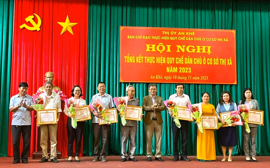 Bí thư Thị ủy An Khê Nguyễn Xuân Phước (thứ 5 bên phải sang) cùng Phó Chủ tịch Thường trực HĐND thị xã An Khê Nguyễn Đức Thành (bìa trái) tặng giấy khen các tập thể có thành tích. Ảnh: Thế Huynh