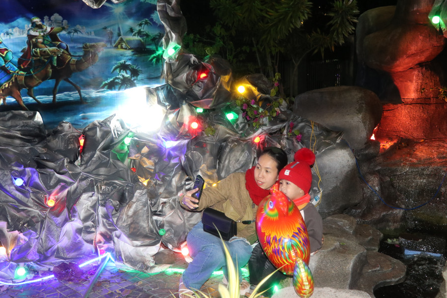 Mẹ con chị Lê Thị Hồng Thanh (thôn Tân Bình, xã Tân An, huyện Đak Pơ) chụp hình lưu niệm trước hang đá tại Nhà thờ Giáo xứ An Khê. Ảnh: Ngọc Minh