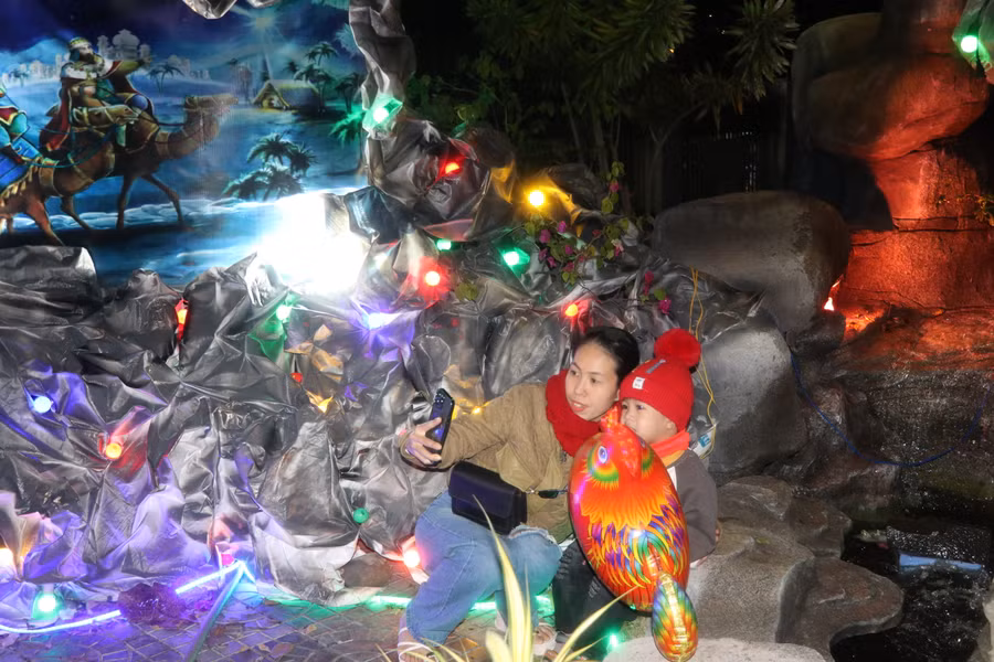 Mẹ con chị Lê Thị Hồng Thanh (thôn Tân Bình, xã Tân An, huyện Đak Pơ) chụp hình lưu niệm trước hang đá tại Nhà thờ Giáo xứ An Khê. Ảnh: Ngọc Minh