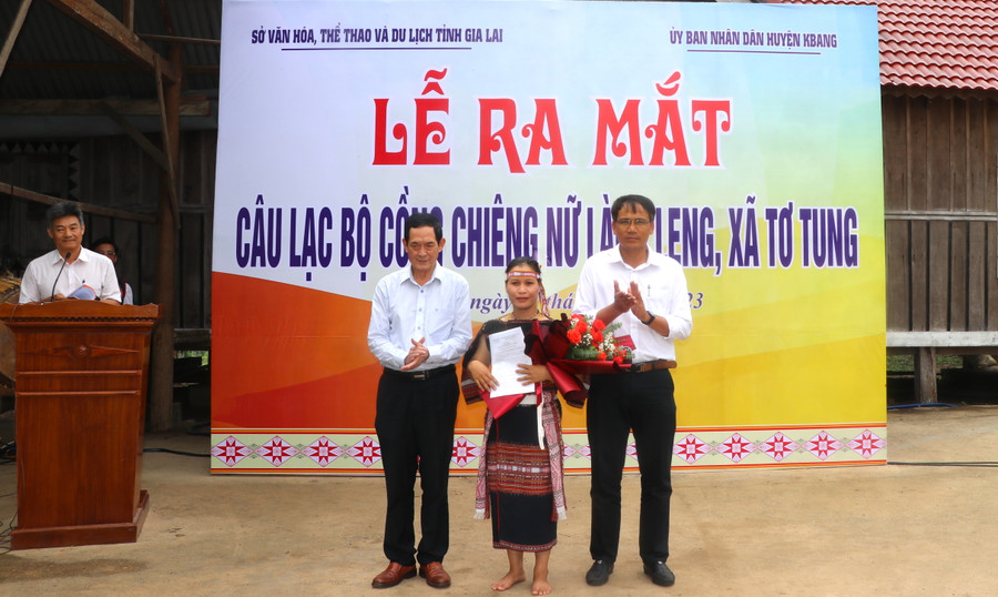 Đại diện lãnh đạo Sở Văn hóa-Thể thao và Du lịch tỉnh và UBND huyện Kbang tặng hoa chúc mừng, trao quyết định cho thành viên CLB Cồng chiêng nữ làng Leng. Ảnh: Ngọc Minh
