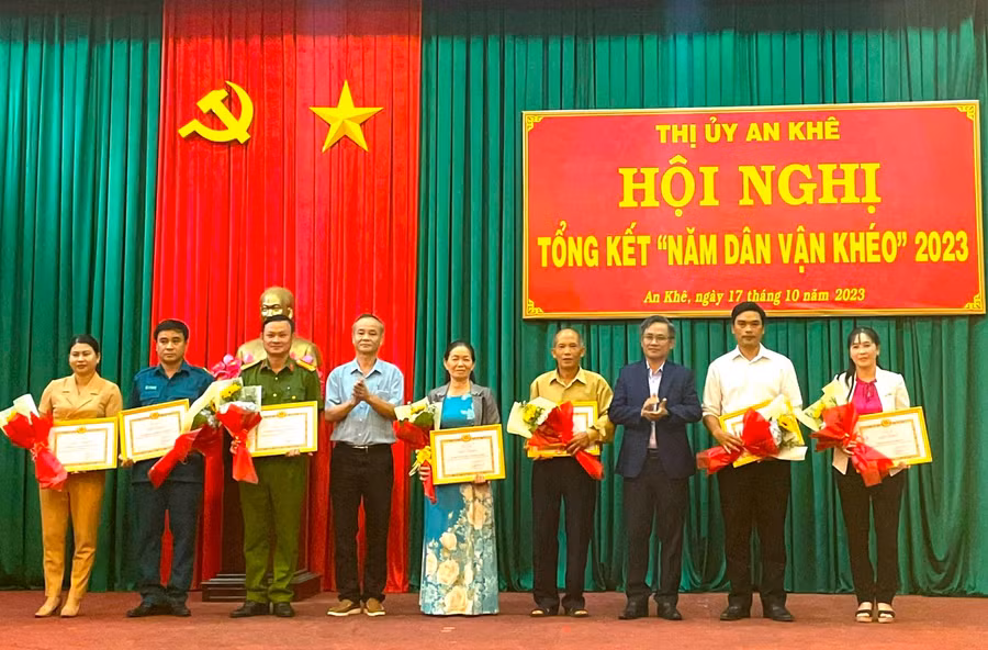 Bí thư Thị ủy An Khê Nguyễn Xuân Phước (thứ 3 bên phải) và Phó Bí thư Thị ủy, Chủ tịch UBND thị xã An Khê Nguyễn Hùng Vỹ (thứ 4 bên trái) tặng giấy khen các tập thể có thành tích xuất sắc. Ảnh: Ngọc Minh