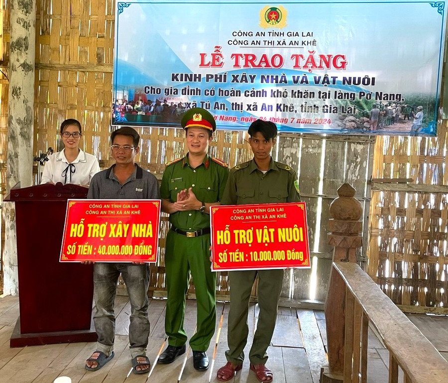 Thượng tá Nguyễn Thành Huy-Trưởng Công an thị xã An Khê tặng kinh phí và vật nuôi cho gia đình có hoàn cảnh khó khăn ở làng Pơ Nang, xã Tú An. Ảnh: Ngọc Minh